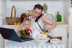 Working Mother With Baby In Kitchen